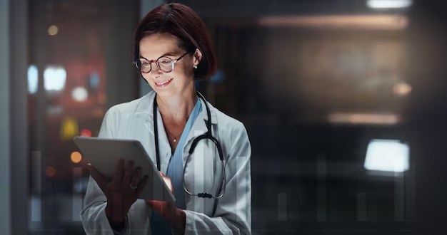 Healthcare provider reviewing patient records on a tablet